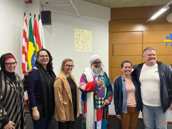 Le Shaykh avec les organisateurs de la rencontre, devant les drapeaux